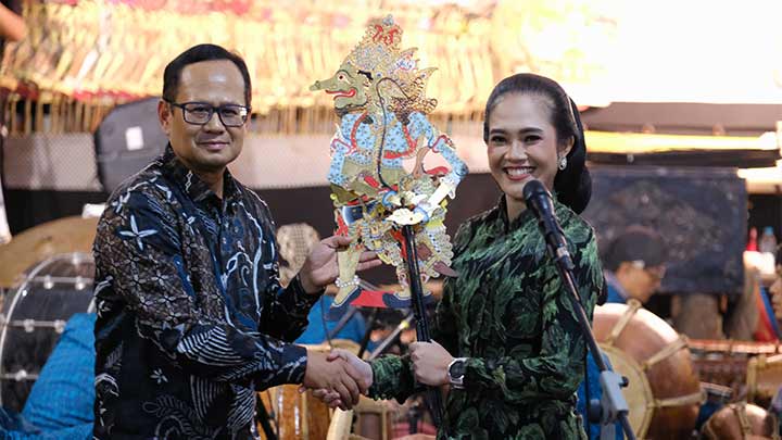 Rektor USD, Albertus Bagus Laksana, SJ menyerahkan wayang 'Petruk Dadi Ratu'kepada dalang Ni Elisha Orcarus Allasso, 8 Desember 2023 x